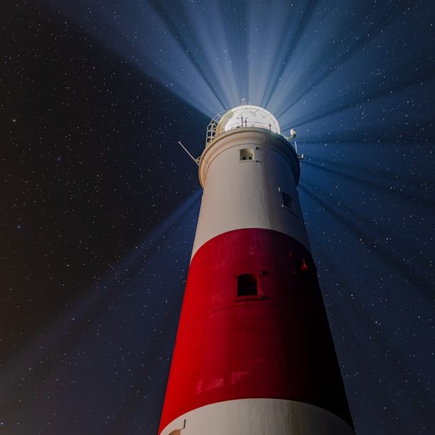 Leuchtturm mit roter und weißer Streifenanordnung, strahlendes Licht in der Nacht.
